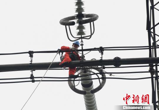 圖為電力工人在70多米高空作業(yè)，為特高壓復奉線重慶段進行八年來首次大修。　周毅 攝